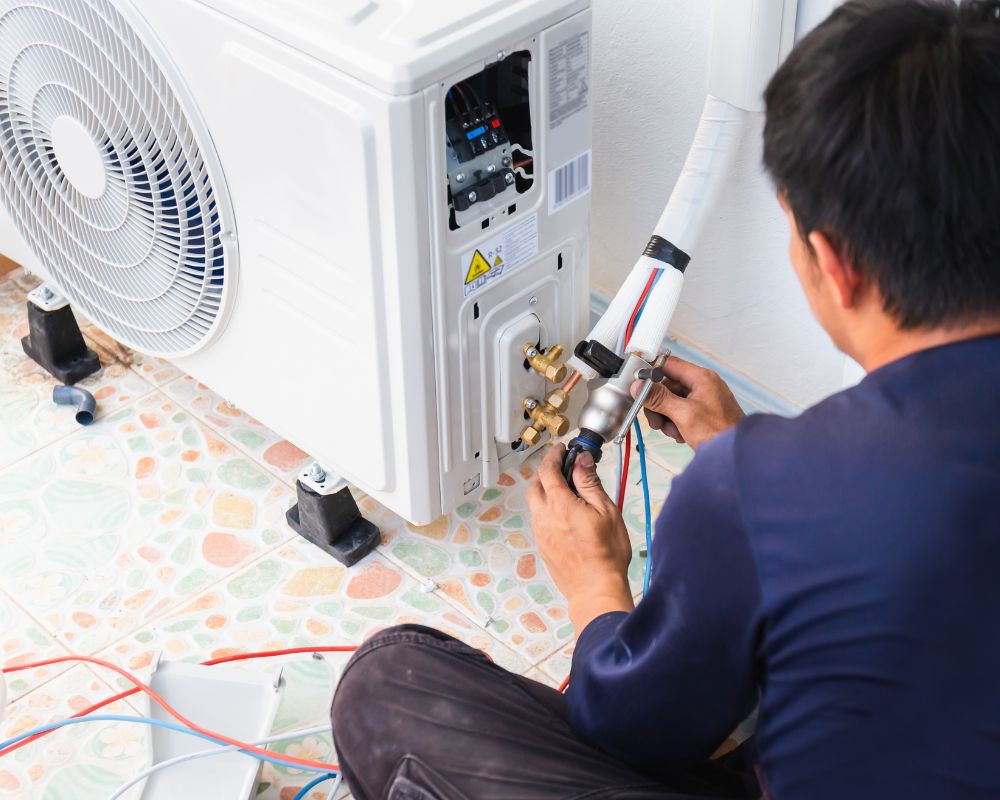 Air conditioner technician repairing central air conditioning system with outdoor tools